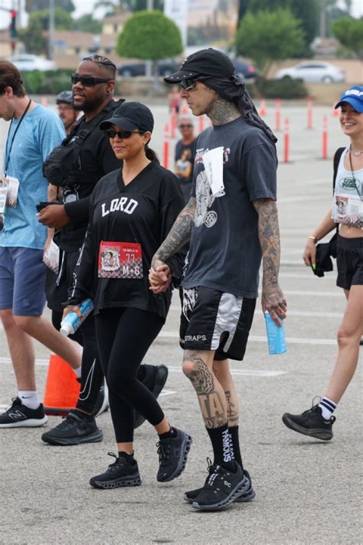 Kourtney Kardashian cheers on Travis Barker as he runs beach marathon in rare outing after giving birth to son Rocky